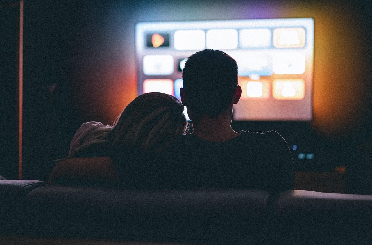 Casal assistindo filme juntos.