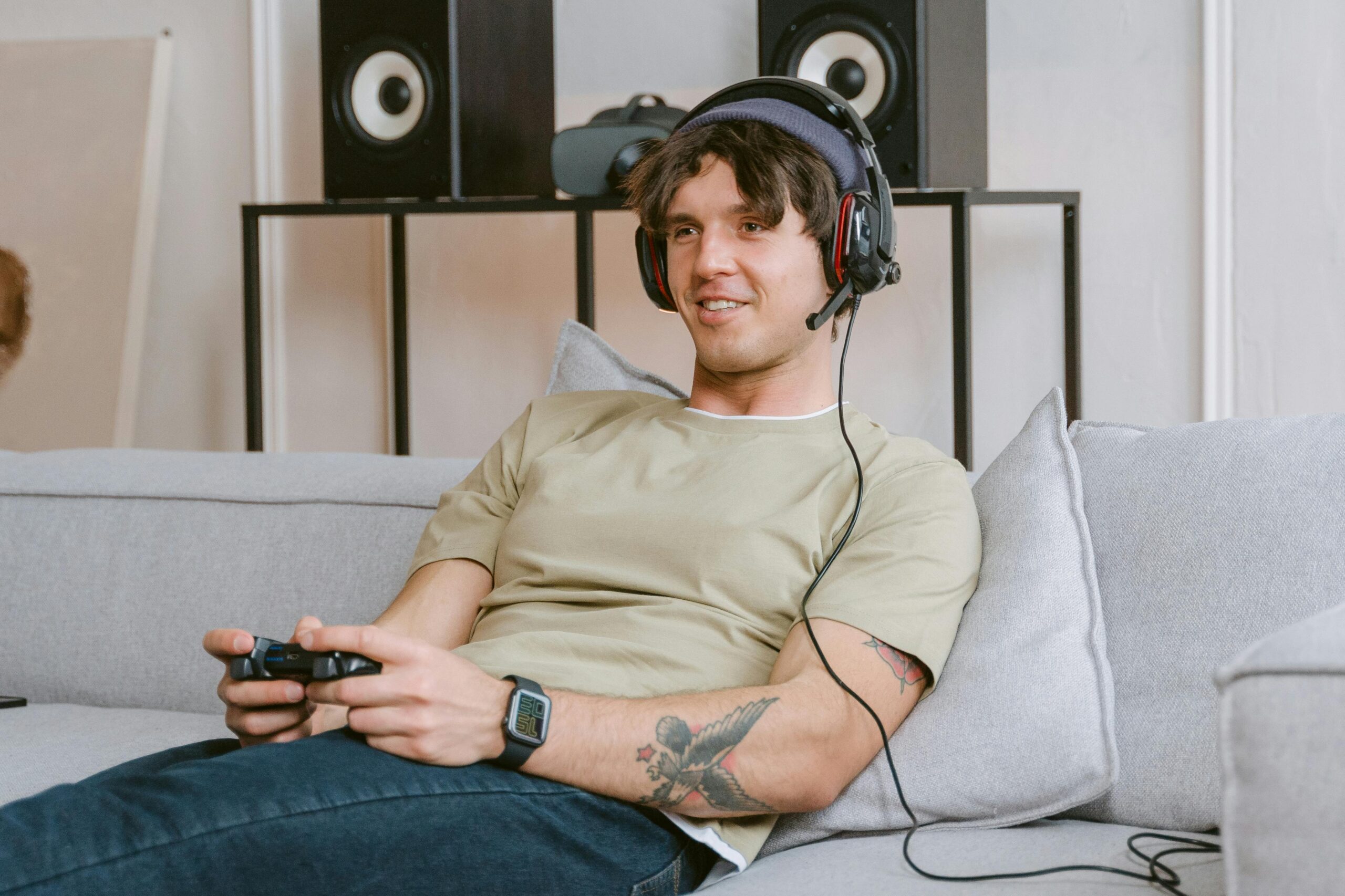 Jovem jogando videogame no sofá.